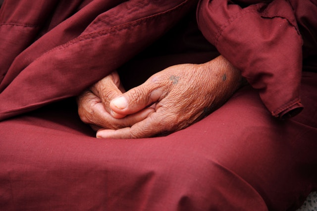Weiterentwicklung - Gefaltene Hände eines Mönchs