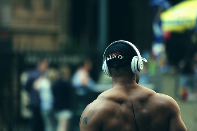 Motivation zum Sport: Ein muskulöser Mann mit Kopfhörern und Basecap